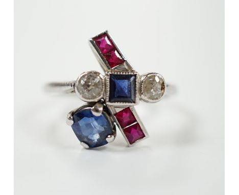 An unusual 1920's/1930's platinum, ruby, sapphire and diamond cluster set dress ring, of free form, the stones in a millegrai