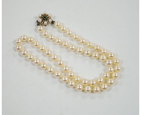 A single strand cultured pearl necklace, with cultured pearl and emerald set 585 yellow metal clasp, 49cm.