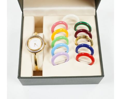 A lady's modern gilt Gucci quartz bangle wrist watch, with twelve interchangeable bezels, in original Gucci box.