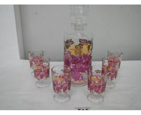 A mid 20th century boxed decanter and glass set decorated with red and gold transfers.