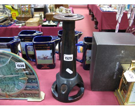 An Arts and Crafts Treacle Glazed Terracotta Candlestick, with circular drip rim, tapering body, tripod feet to ring base, 30
