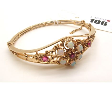 A 9ct Gold Victorian Style Bangle, of graduated openwork design, claws set with opal and ruby highlights, on reeded bangle, h