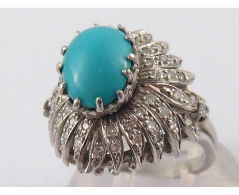 A white metal (tests 14 carat gold) turquoise and diamond ring, turquoise approx 10.5 x 7.5mm, ring size M, 7.6 gms.