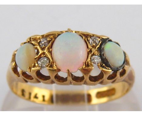 An 18 carat gold opal and diamond ring, hallmarked Birmingham 1924, largest opal approx 5.5 x 4.5mm, ring size N, 2.8 gms.
