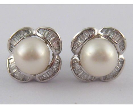 A pair of white metal (tests 14 carat gold) baguette cut diamond and cultured pearl ear studs, pearls approx 6.5mm diameter, 