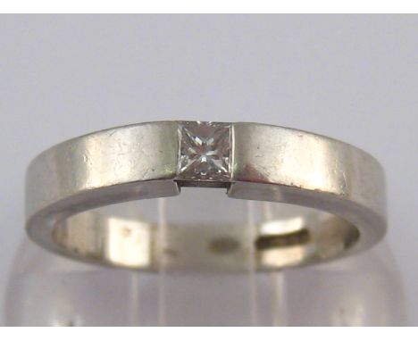 A platinum and diamond solitaire ring, the rectangular channel set diamond measuring approx 3mm wide, ring size K, 5.3 gms.
