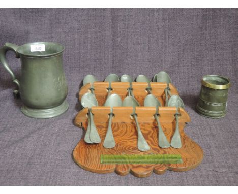 A collection of Vintage pewter spoons on pitch pine rack, a 19th century pewter tankard and a small brass rim half pint tanka