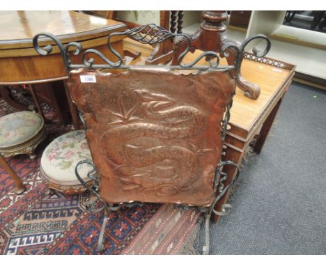An Art Nouveau wrought iron frame firescreen having copper panel with dragon design