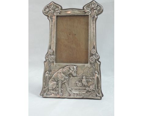 An Edwardian silver Art Nouveau design photograph frame having embossed decoration depicting a dog and chicks in countryside 