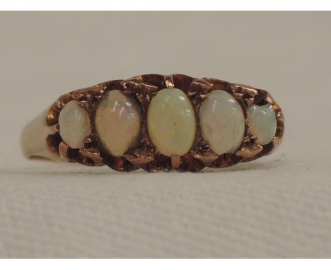 A lady's dress ring having five graduated opals in a gallery claw mount on a 9ct rose gold loop, size O/P
