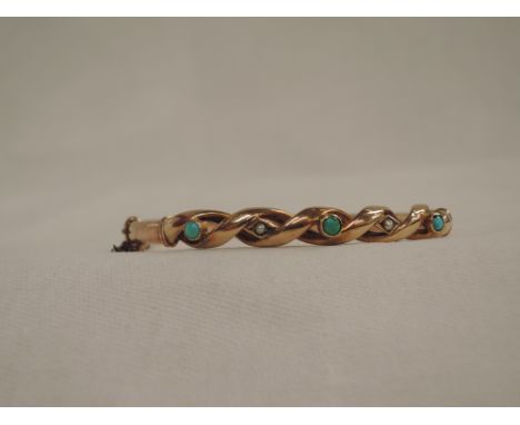 A Victorian rose gold hinged bangle stamped 9ct having open twist detail with turquoise and seed pearl decorationIn good cond