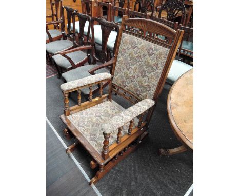 A late 19th century mahogany American rocking armchair having spindle frame later 20th century tapestry upholstery