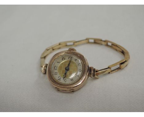 A vintage 9ct rose gold wrist watch having Arabic numeral dial to chequered face in a rose gold case on a rolled gold stretch