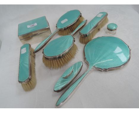 An eight piece HM silver dressing table set consisting of four brushes, hand mirror, box. Glass pot and nail buffer, all havi