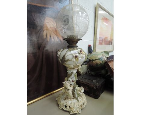 A Victorian oil lamp having ceramic reservoir and column of scroll and flower design, with etched glass globeExtentse damage 