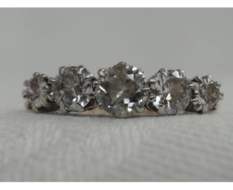 A lady's dress ring having five graduated diamonds, approx .70ct in a raised claw mount on a yellow metal loop stamped 18ct &