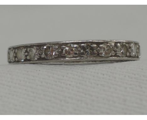 A diamond full eternity ring having worn decoration to sides, no marks possibly platinum,  size M