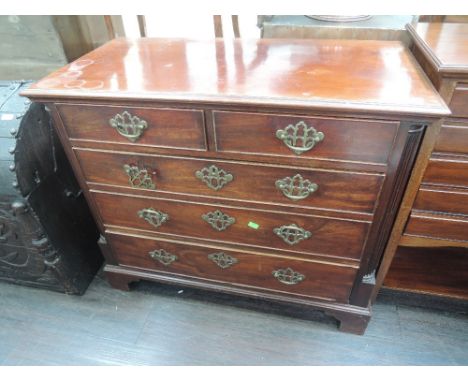 An early 19th century mahogany chest of 2 short and 3 long cockbeaded drawers, flanked by half reeded pillars, on bracket fee
