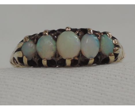 A lady's dress ring having five graduated opals in a gallery mount on an 18ct rose gold mount, Chester hallmark, size N