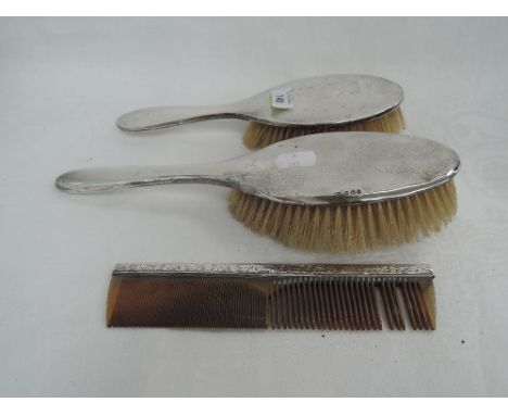 Two HM silver dressing table brushes of plain form and an HM silver backed comb, various hallmarks 