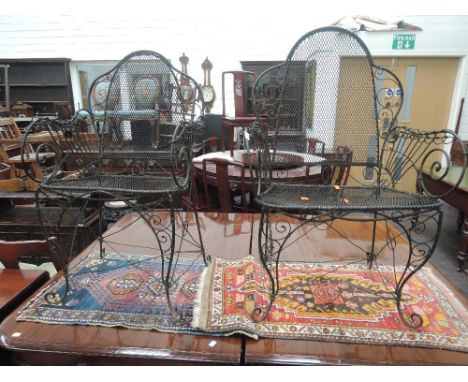 Two vintage black wrought iron conservatory/garden armchairs having wirework scroll decoration