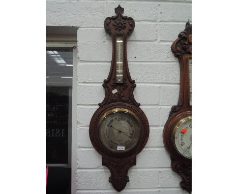 An early 20th century oak aneroid banjo case barometer having thermometer scale labelled Thos Armstrong & Bro, Deansgate, Man