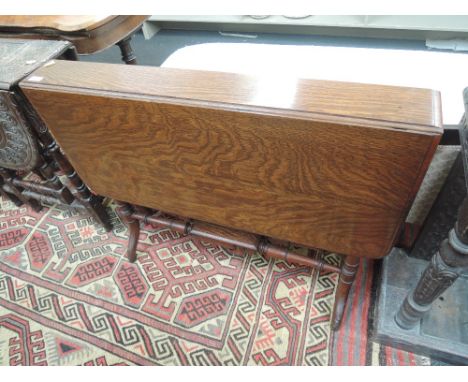 A late Victorian/Edwardian oak sutherland table having drop flap  top on ring turned gate legs and double stretchers