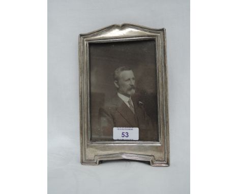 A silver photograph frame of arched rectangular form having wooden easel stand, Chester 1913, makers mark worn