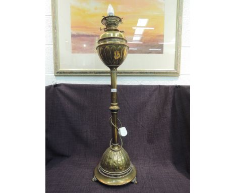 An early 20th century brass floor standing oil room/table lamp having petal decoration and converted to electric  