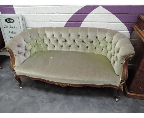 A 19th century mahogany frame salon settee in the French style having 20th century green button dralon upholstery on applique