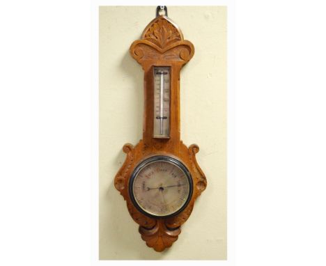 Early 20th Century carved oak framed aneroid barometer and thermometer having a silvered dial and scale   Condition: 