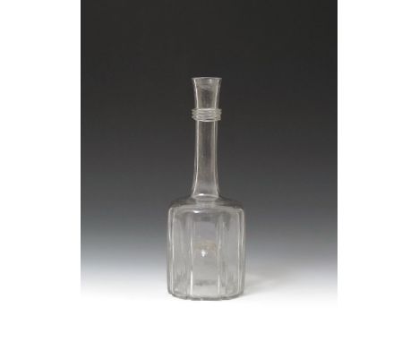 A glass serving bottle or decanter  c.1740, the squat body moulded with eight sides, rising to a straight neck with triple ap