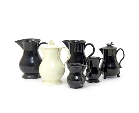 Five Jackfield jugs  18th century, one with a cover and raised on three paw feet, the rest raised on circular bases, and a cr
