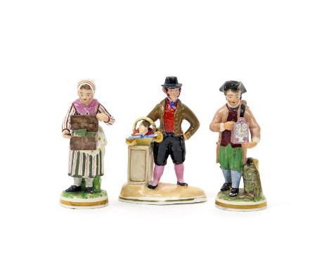 A pair of Derby figures of street traders  c.1820, one of a lady selling trinkets from a box, the other of a gentleman demons