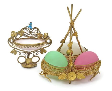 A Continental trinket or bonbon stand  19th century, formed as three opaque coloured glass eggs in a nest of gilt metal rope 