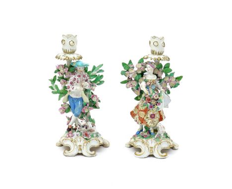 A pair of Chelsea candlestick figures of a musical shepherd and his companion  c.1765, he standing and playing the flageolet 
