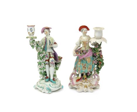 Two Derby candlestick figures  c.1760-70, one of a floral shepherdess with an apron full of flowers, raised on a scroll base 