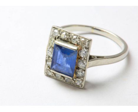 An Art Deco sapphire and diamond ring, rectangular step-cut sapphire measuring 7x5.82x3.22mm, surrounded by fourteen old cut 