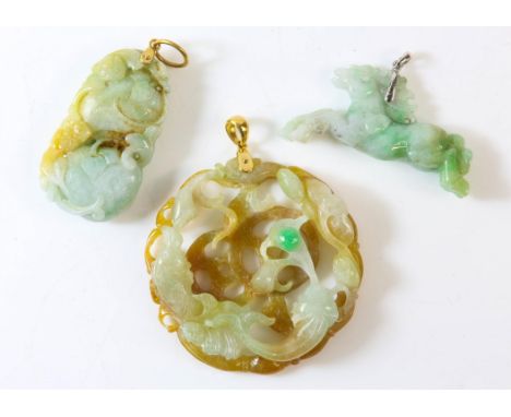 Three carved jade pendants, one of a carved horse, one with a carved goldfish, both with articulated bails stamped 18ct, and 
