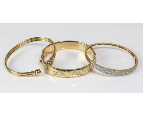 AMENDED DESCRIPTION - Two gold bangles, including a torque bangle, and a hinged bangles, with a white metal textured panel se