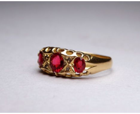 An 18ct yellow gold three stone garnet dress ring - with a pierced open setting, ring size P/Q, weight 2.5g.