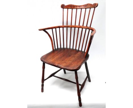 An early 19th century ash and elm comb back Windsor chair - of West Country type, probably Cornish, the shaped top rail above