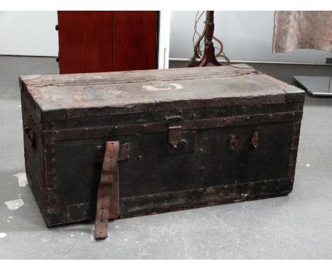 An early 20th century car trunk - covered in black oil-cloth with steel banding and brass corners, the interior finished in a