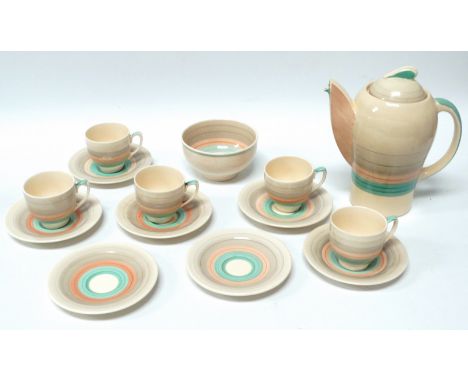 A Susie Cooper Art Deco coffee service - with 'Kestrel' pattern coffee pot, five cups, seven saucers and a sucrier, decorated