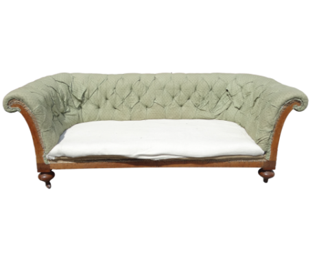 A late Victorian walnut and upholstered Chesterfield sofa - of typical buttoned form and raised on bulbous turned legs ending