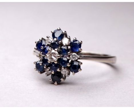 An 18ct white gold blue topaz and diamond set ring - the cluster setting in three steps, ring size W, weight 4.7g.