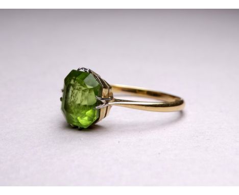 An 18ct yellow gold ring set with peridot - the emerald cut stone with a claw setting, ring size T, weight 3.2g.