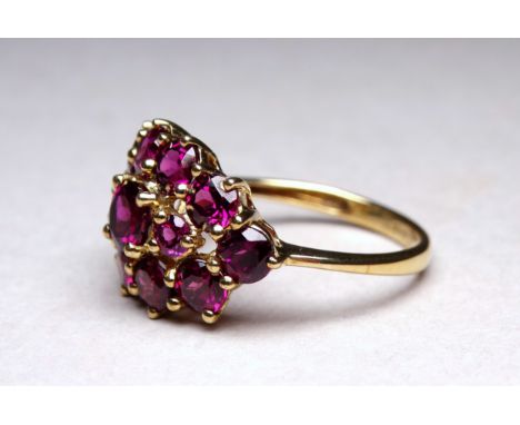A 9ct yellow gold garnet cluster ring - with an arrangement of thirteen claw set stones, ring size Q, weight 3.7g.