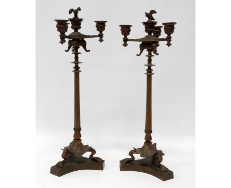 A pair of Italian Renaissance candlesticks - with four sconces and three elephant masks on a fluted support and tripod base w