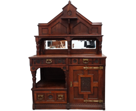 An Aesthetic Movement oak sideboard - of asymmetrical design, the mirrored raised back incorporating shelves and two bevelled